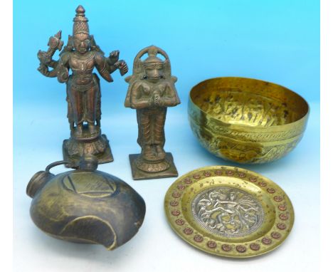 A brass bowl decorated with a scene of a lion chasing a deer, two cast metal figures of Indian deities, a small Indian dish a