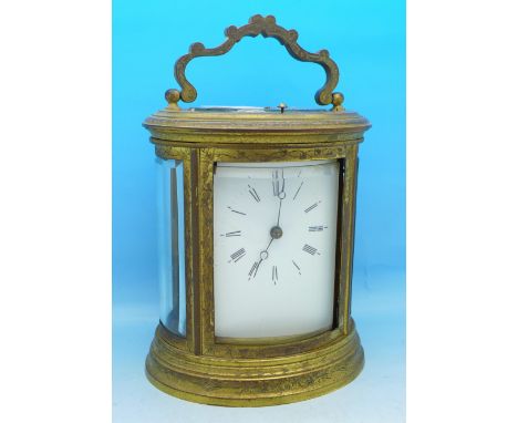 An oval brass and four glass sided chiming carriage clock, 13.5cm