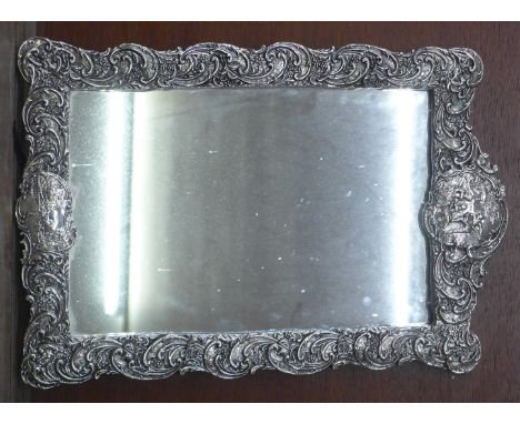 A large silver framed mirror, a/f, silver covered frame, no back stand