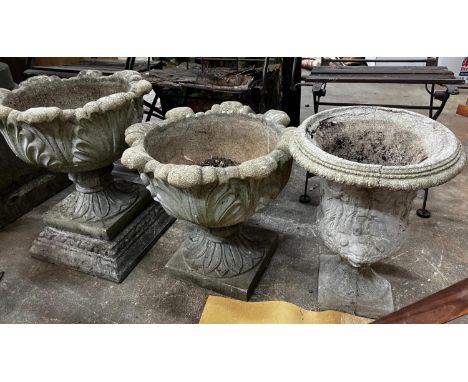 Three circular reconstituted stone garden urns, the largest diameter 48cm, height 55cm