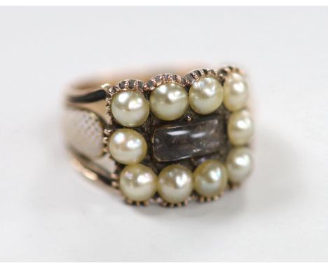 A 19th century yellow metal, plaited hair, enamel and split pearl set mourning ring, size P, gross weight 5.3 grams, the shou