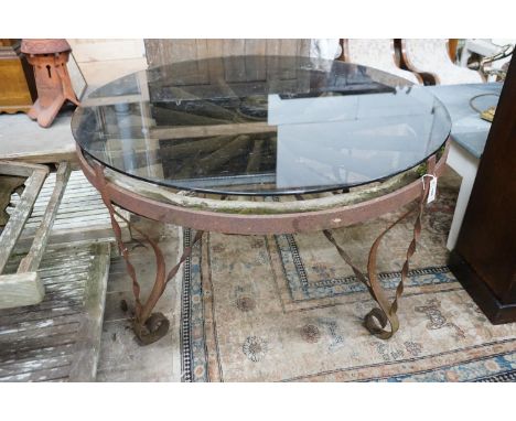 A wrought iron glass topped circular cartwheel garden table, diameter 124cm, height 72cm