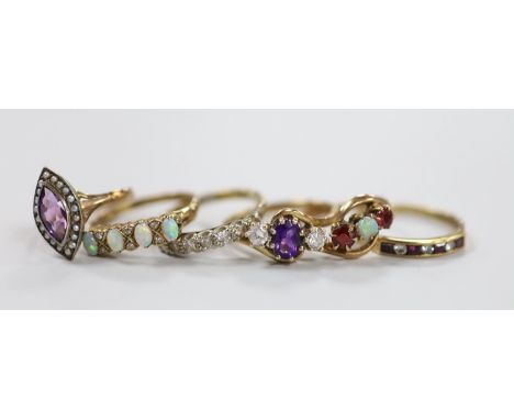 Six assorted modern 9ct and gem set rings, including an amethyst and diamond set three stone crossover ring, size R, white op