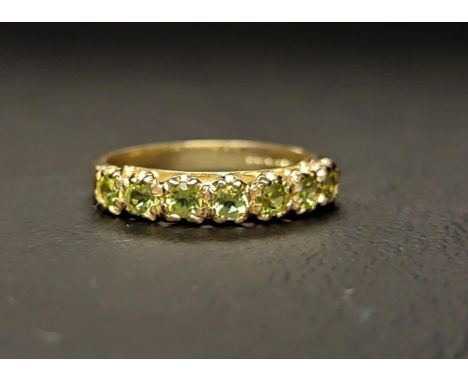 PERIDOT HALF ETERNITY RING the seven round cut peridots totalling approximately 0.50cts on a nine carat gold shank, ring size