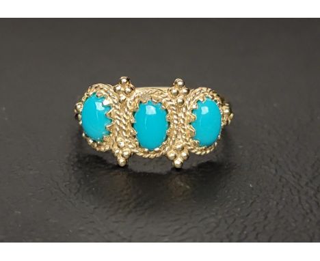 TURQUOISE THREE STONE RING with three oval cabochon turquoise sections in a decorative setting, on a nine carat gold shank, r