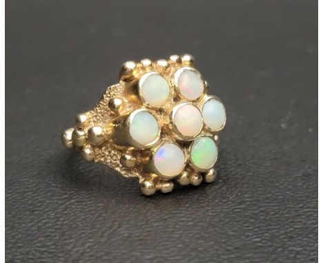 IMPRESSIVE OPAL CLUSTER RINGthe seven round cabochon opals in moulded setting with ball detail, in nine carat gold, ring size