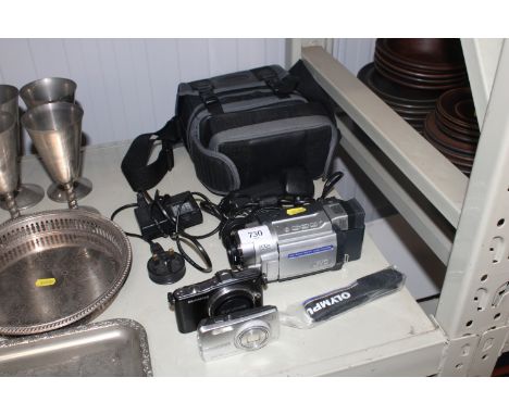 A JVC camcorder; an Olympus pen mini camera; another Olympus camera and various accessories 