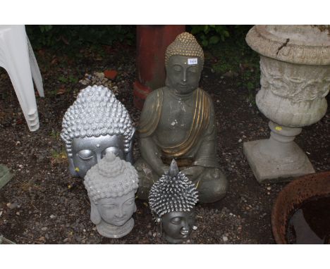 Three garden ornaments in the form of Buddha's heads and another in the form of a seated Buddha