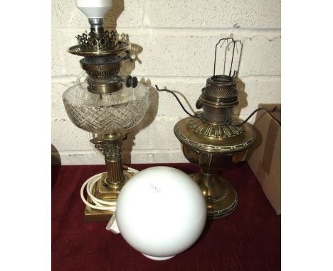 A brass oil lamp in the form of a short Corinthian column candlestick, with cut-glass reservoir and electrified burner, chimn