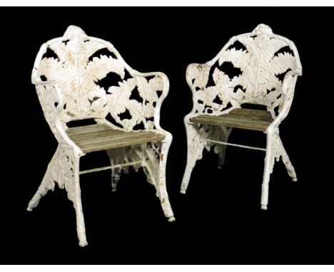 A pair of Victorian cast iron fern pattern garden chairs in the manner of Coalbrookdale, each with a wooden slated seat and l