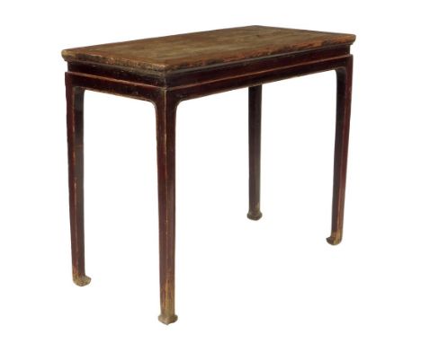 A Chinese elm table, with traces of red lacquered decoration, on scroll feet, 86.3cm high, 102cm wide, 51cm deep.