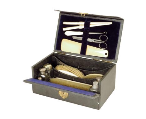 λ A Victorian black leather gentleman's dressing case, the hinged lid with a sunken brass handle, the interior fitted with iv