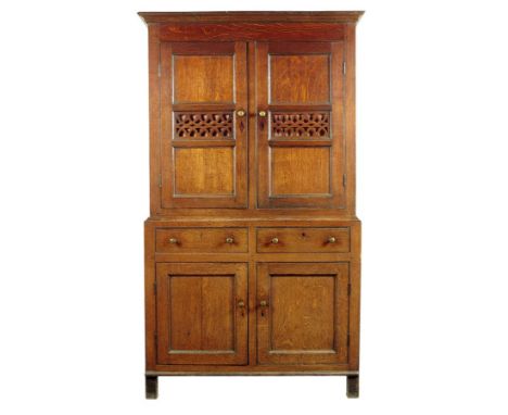 A George III Welsh oak and scumbled pine food cupboard, with a pair of panelled cupboard doors with pierced fretwork panels, 