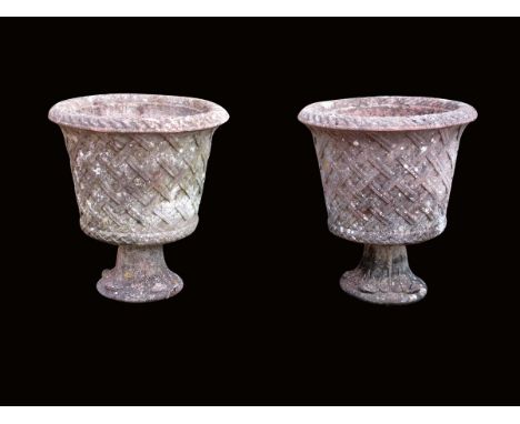 A pair of terracotta basket weave garden urns, with lappet decorated socle bases, 73cm high, 64cm wide. (2)