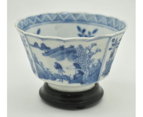 A Qing Dynasty blue and white cup. The cup depicting pots of plants and figurines to exterior. Pots of flowers and scrolling 