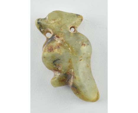 A celadon and russet jade figure of a bird. The figure has carved with large raised eyes with&nbsp;stylised wings. Measures a