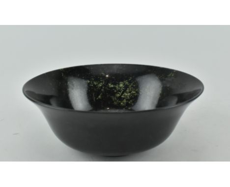A Republic Period moss green jade bowl of circular form raised on circular foot. Measures approx. 5.5cm tall, 15cm diameter.