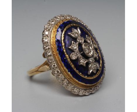 A DIAMOND AND ENAMEL DRESS RING, the large oval boss centred by a panel of point set stones on a blue guilloche enamel ground