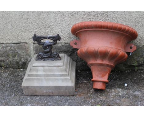 A CAST IRON BOOT SCRAPER modelled as two entwined dolphins, raised on a stepped and moulded oblong base, 13 1/4" x 15", toget