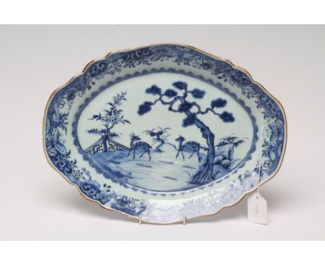 A CHINESE PORCELAIN DISH of lobed oval form, painted in underglaze blue with two spotted deer in landscape within a stylised 