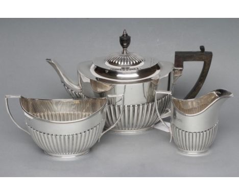 A SILVER COMPOSITE THREE PIECE TEA SERVICE, maker Huttons, London 1901, 1904 (teapot) and 1923 (sugar), of semi fluted oval f