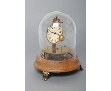 A BRIGGS TORSION ROTARY BALL PENDULUM CLOCK, the 2 1/4" enamel dial with Roman numerals, raised on moulded circular wood base