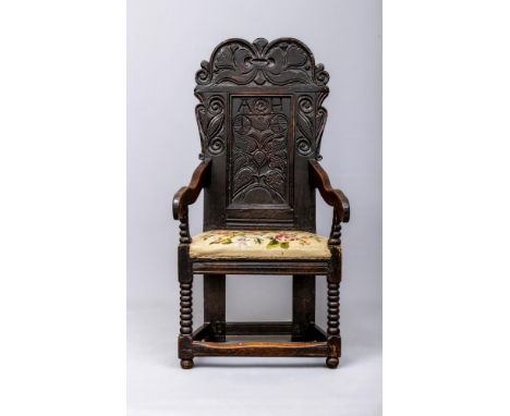 A JOINED OAK ARMCHAIR, Leeds Yorkshire, mid/late 17th century, the arched top rail carved with foliage and scrolls, fielded b