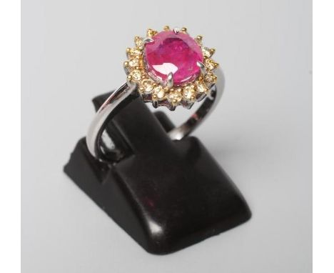 A RUBY AND DIAMOND CLUSTER RING, the brilliant cut ruby of 1.30cts claw set to a border of sixteen fancy yellow small diamond