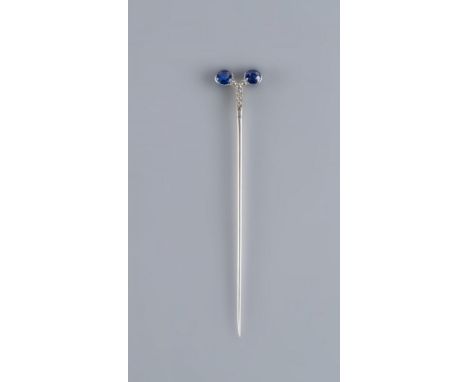 A CARTIER SAPPHIRE AND DIAMOND STICK PIN by Henri Droguet, the two round facet cut sapphires collet set to a 'Y', point set w