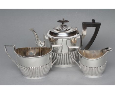 A BACHELOR'S THREE PIECE SILVER TEA SERVICE, maker Walker & Hall, Sheffield 1914 (teapot) and 1915, of semi fluted oval form,