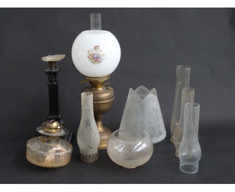 A late Victorian painted brass oil lamp base, together with a brass oil lamp, two shades and four chimneys