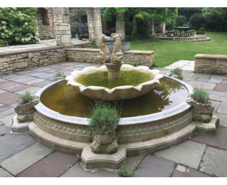 A large stone water feature / courtyard centrepiece with nautilus shell jardinieres, two tier waterfall and fish finial, 3.6m