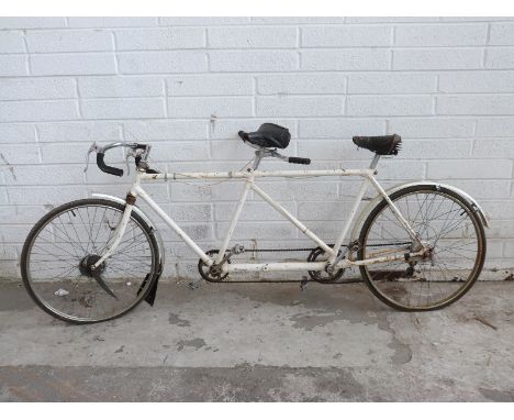 A vintage tandem bicycle with white frame and drum brakes 