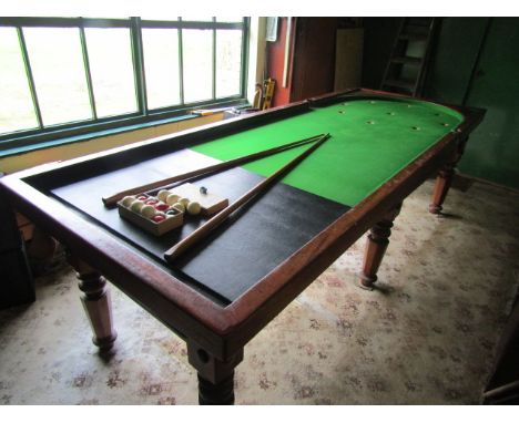 A full size antique Bagatelle/Bar Billiards table, 10ft long, possibly mahogany, with turned legs. 
The top is in great condi