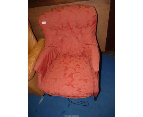 An easy buttonback arm chair in light red fabric.