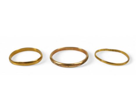 Two gold band rings and a plated band ring, gold rings surface test to approximately 22ct, gold weight 2.3g. (3)
