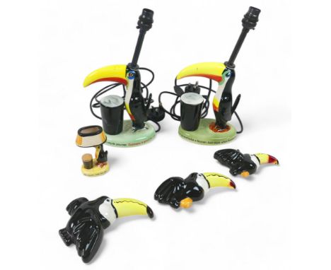Six Toucan ware Guinness related items, comprising two table lamps, Three Andy Titcomb flying Toucans and a small lamp orname