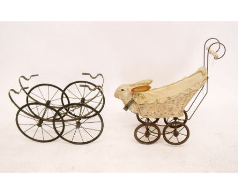 A vintage wicker dolls pram with composition rabbits head to front and a pram base 
