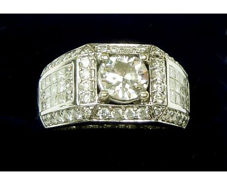 An 18 carat white gold gentleman's diamond ring with pave and channel set diamond surround and shoulders, central stone measu