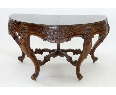 A Chinese demi-lune console table with rosewood top and heavily carved apron all raised on cabriole supports united by stretc