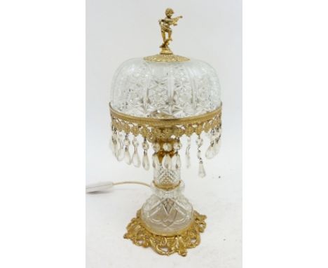 A cut glass and gilt metal table lamp and shade with putti finial 