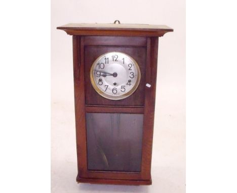 A 1930's oak cased wall clock with glazed door 