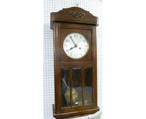 A 1930's oak wall clock with glazed door, 74cm tall 