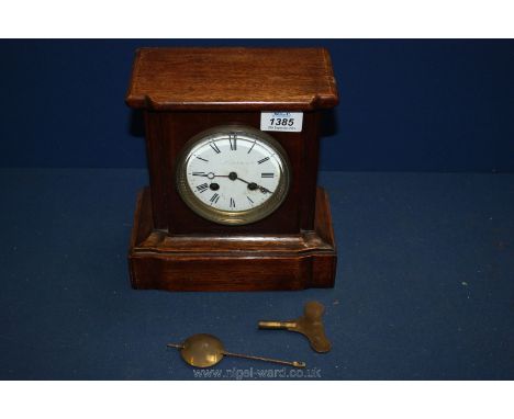 A wooden mantle Clock with pendulum and key