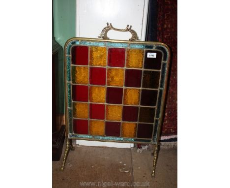 A brass surround Firescreen with leaded glass square detail, standing on two feet