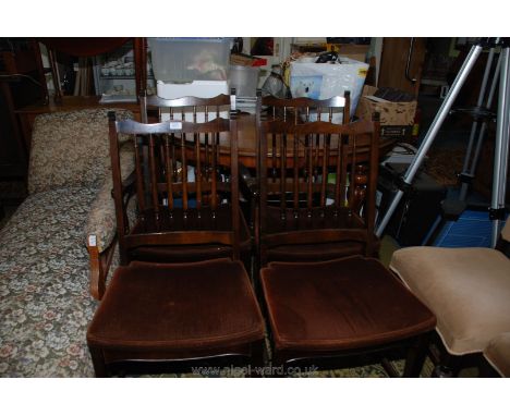 A set of four turned stick back darkwood framed Dining Chairs on tapering square legs and having dark brown dralon upholstere