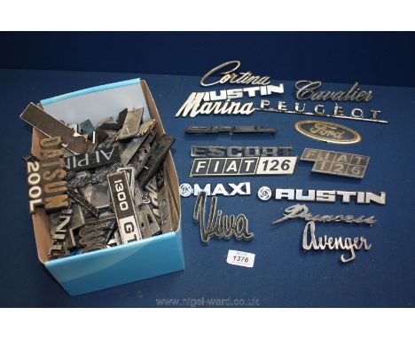 A box of assorted car badges including Austin, Ford, Fiat etc