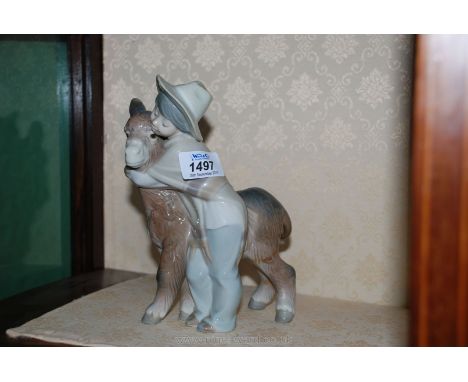 A Lladro figure of a boy hugging a donkey.