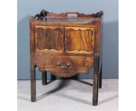 A George III mahogany tray top bedside cabinet with shaped sides and handle cut-outs, fitted cupboard enclosed by a pair of p