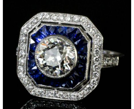 A good 1920's silvery coloured metal diamond and sapphire octagonal faced "halo" ring the collet set central old cut diamond 